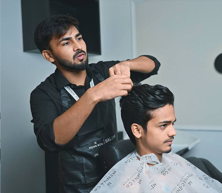Barber cutting a customer's hair in a salon setting